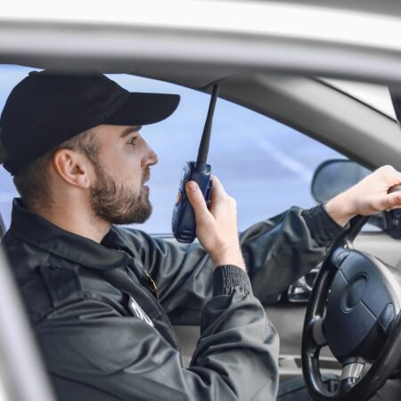 Male police officer driving car