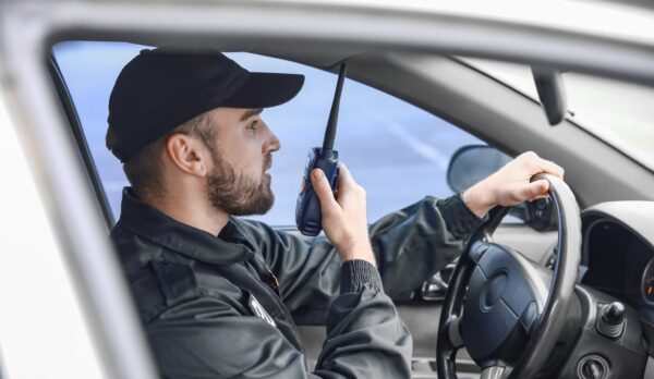 Male police officer driving car